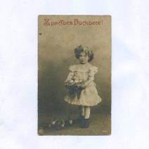 Открытка пасхальная "Христос Воскресе!" Девочка с цветами в волосах и корзинкой яиц. Российская Империя до 1917 г.