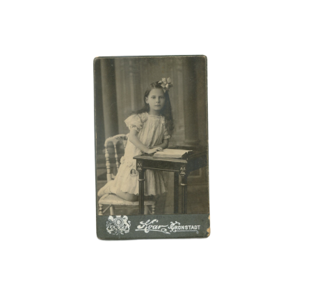 РИ. Квар Ф. Девочка за столиком в белом платье и с бантом. Кронштадт. 1911 г. 6,5 х 10,5 см